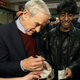 Republican presidential candidate Rep. Ron Paul, R-Texas, signs an autograph on a dollar bill as he visits a caucus site Tuesday, Feb. 7, 2012, in Coon Rapids, Minn. (AP Photo/Charles Rex Arbogast